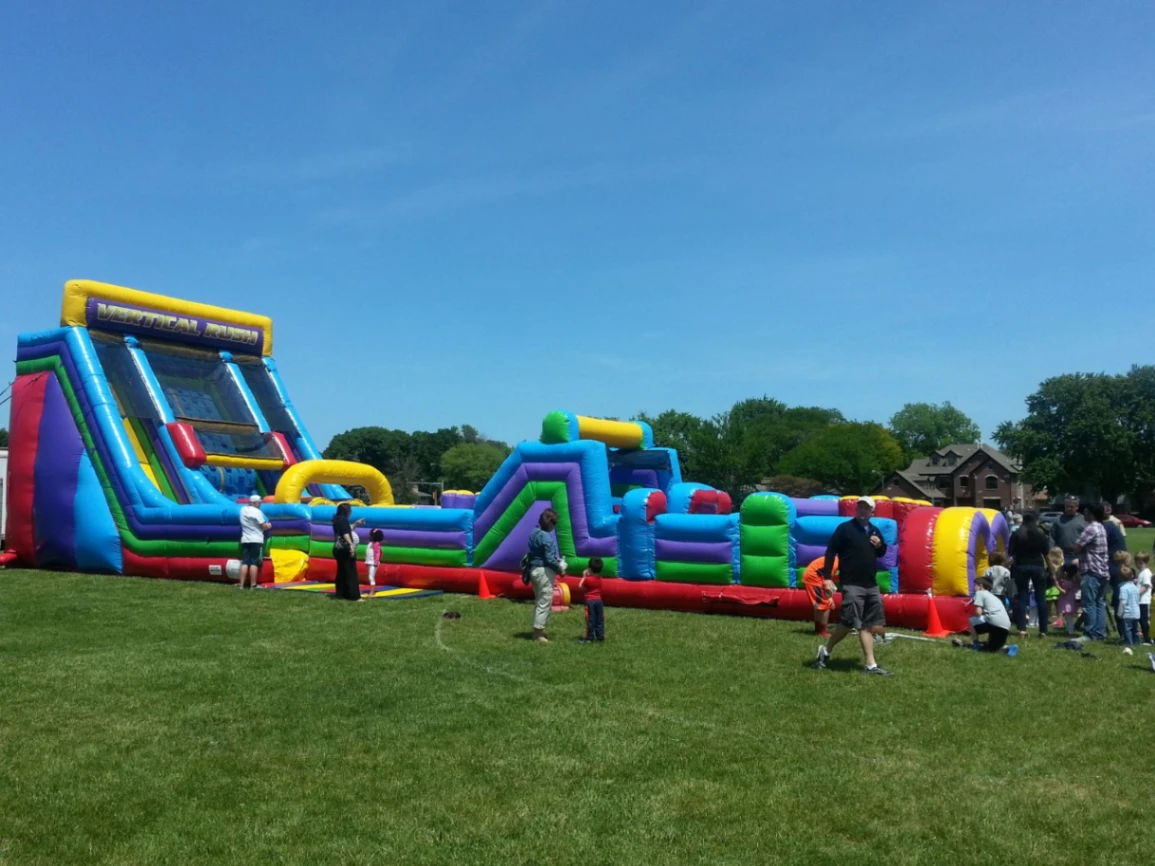Kids racing the dual-lane 70ft Vertical Rush obstacle course rental in Chicago