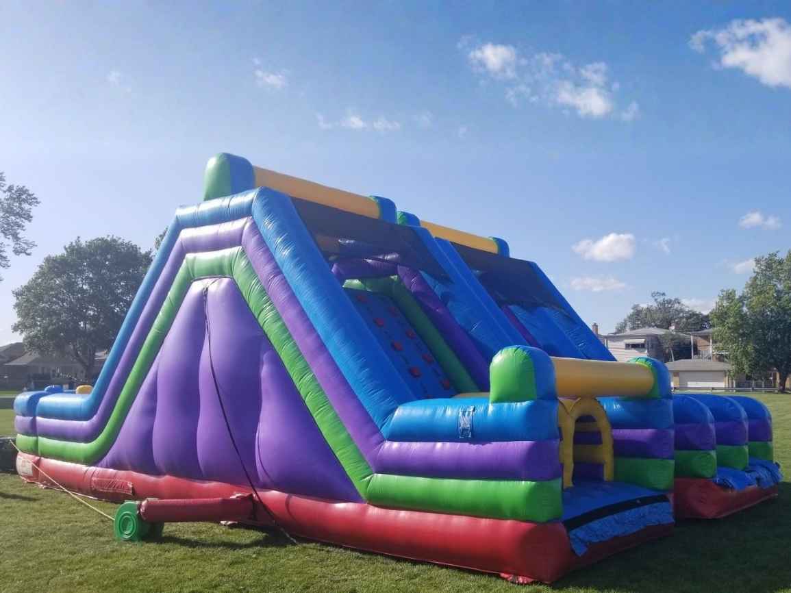 Kids climbing the 75ft Rock Climb Slide obstacle course rental in Chicago
